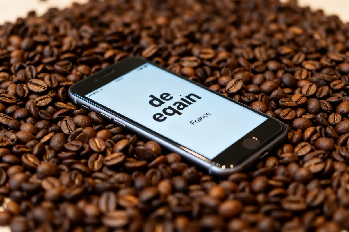 Téléphone sur grains de café de qualité avec texte visible sur l'écran